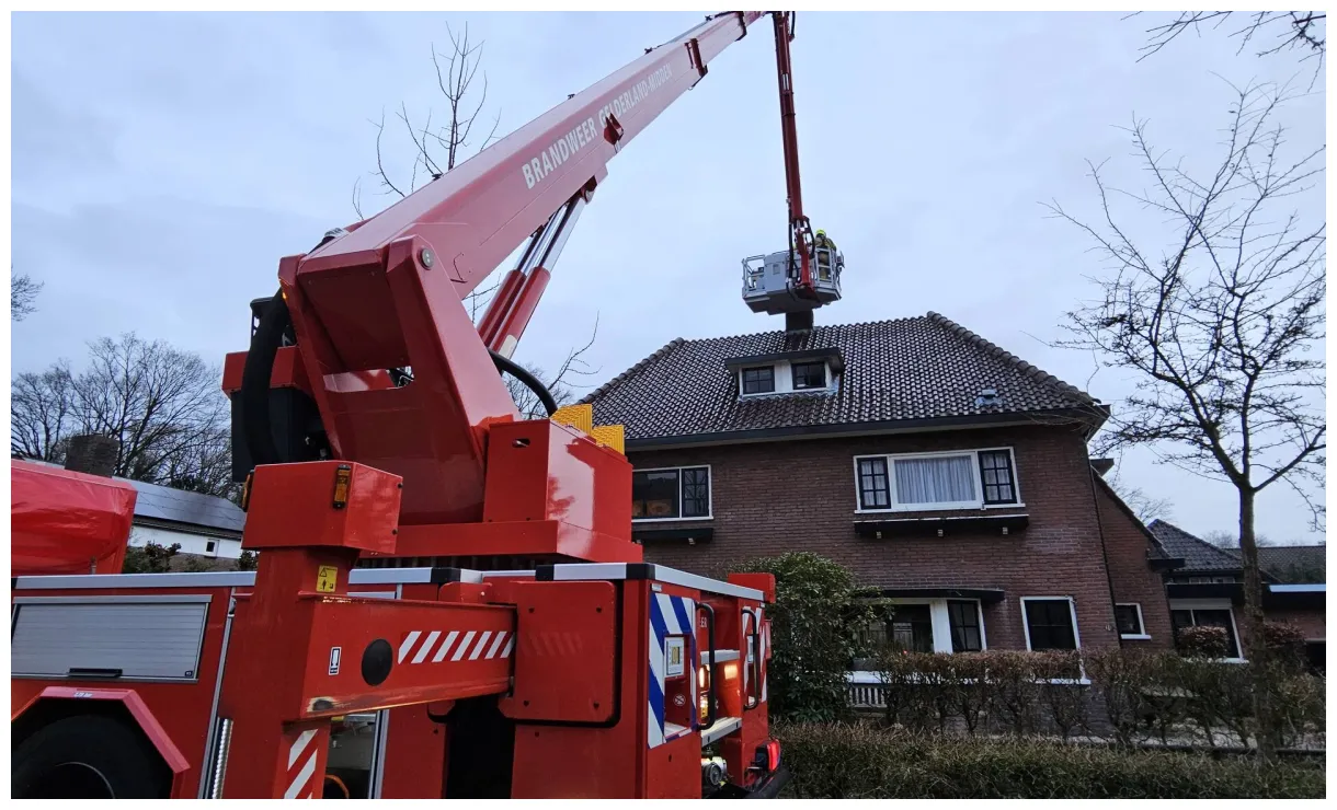 Brandweer veegt schoorsteen van woning in Ede na brand
